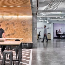 A person standing in a room with tables and chairs.