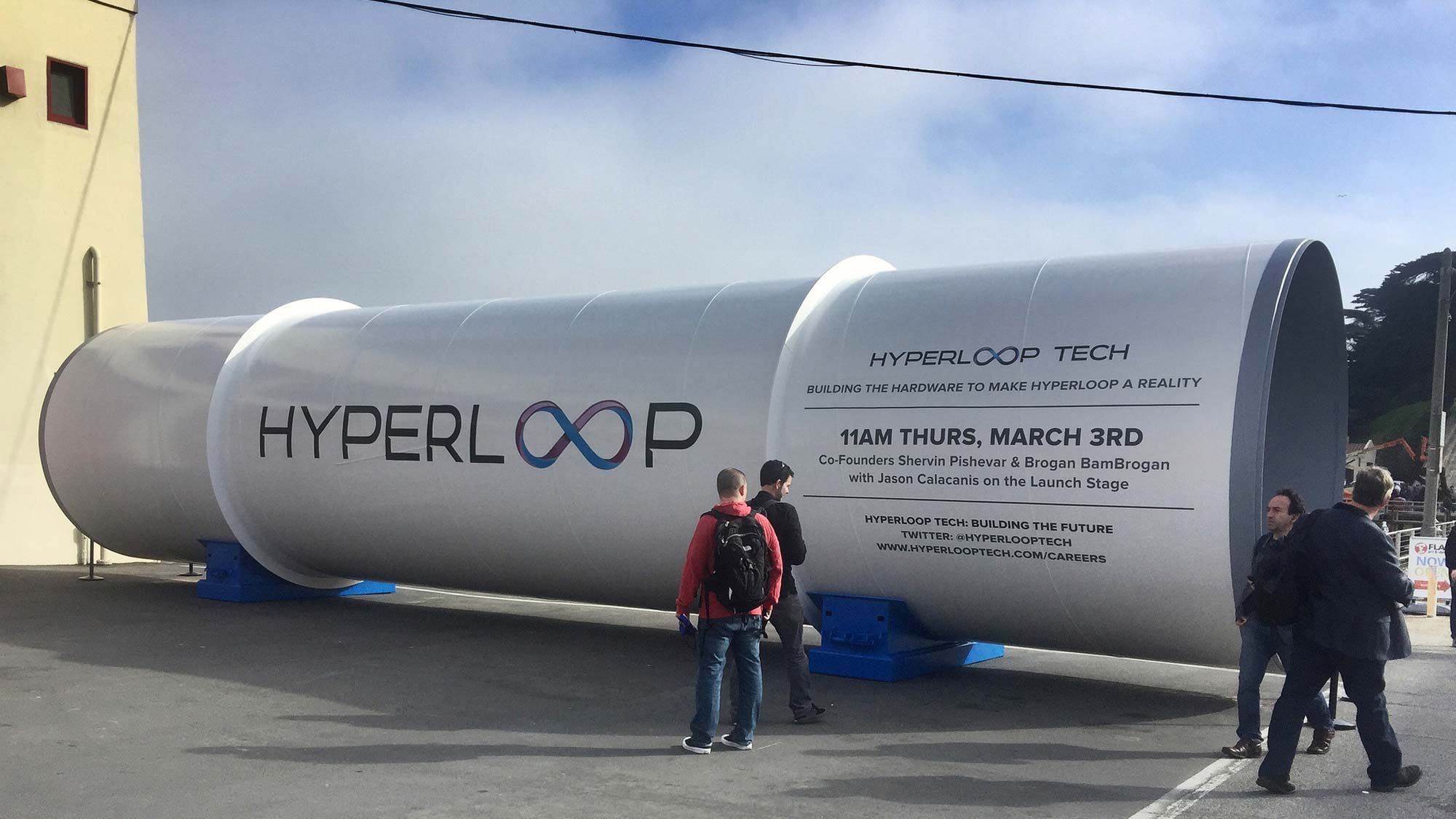 A group of people standing next to a large white rocket.