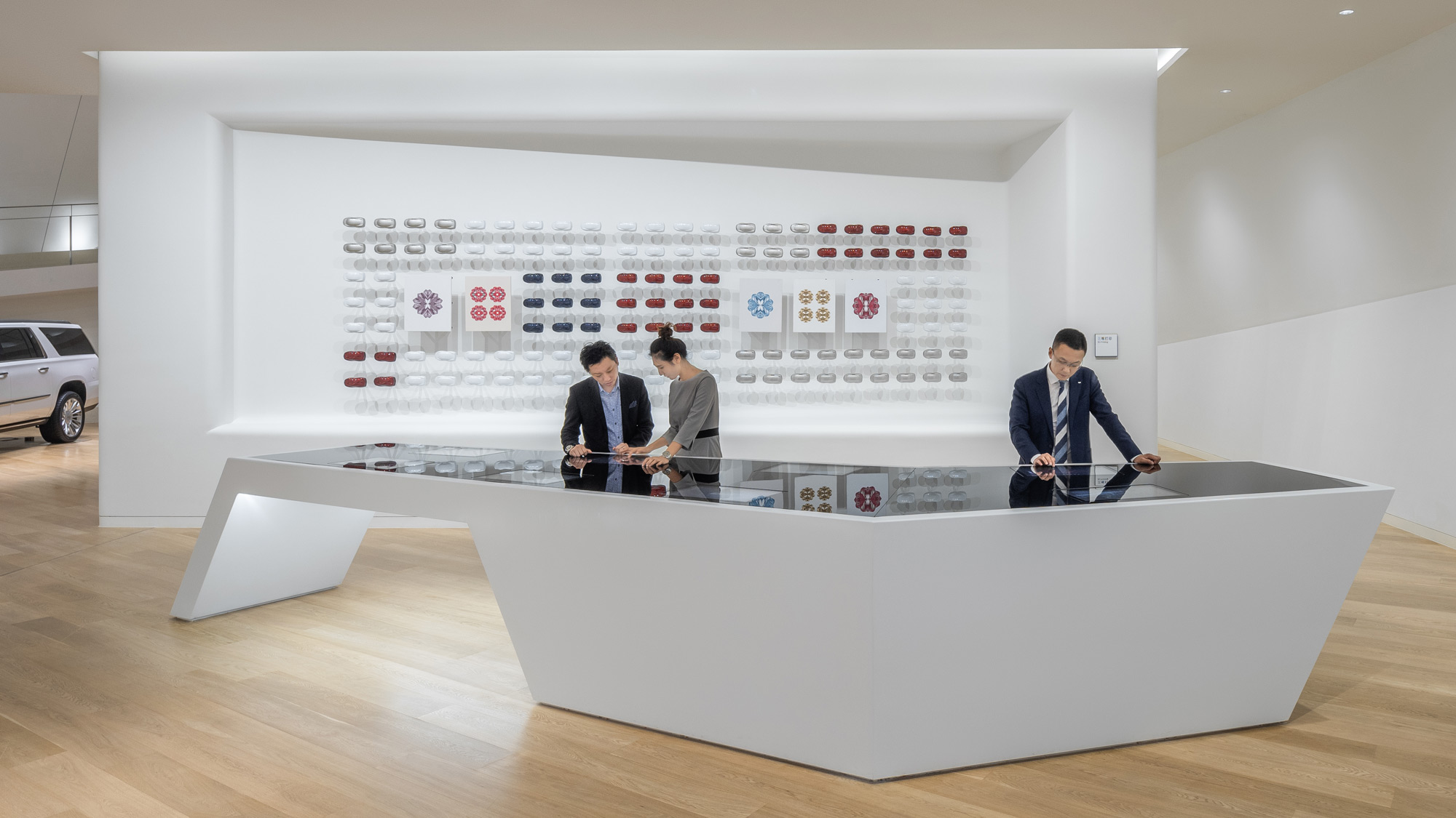 Visitors look at a range of colorful 3D-printed models in a display counter at Cadillac House Shanghai.