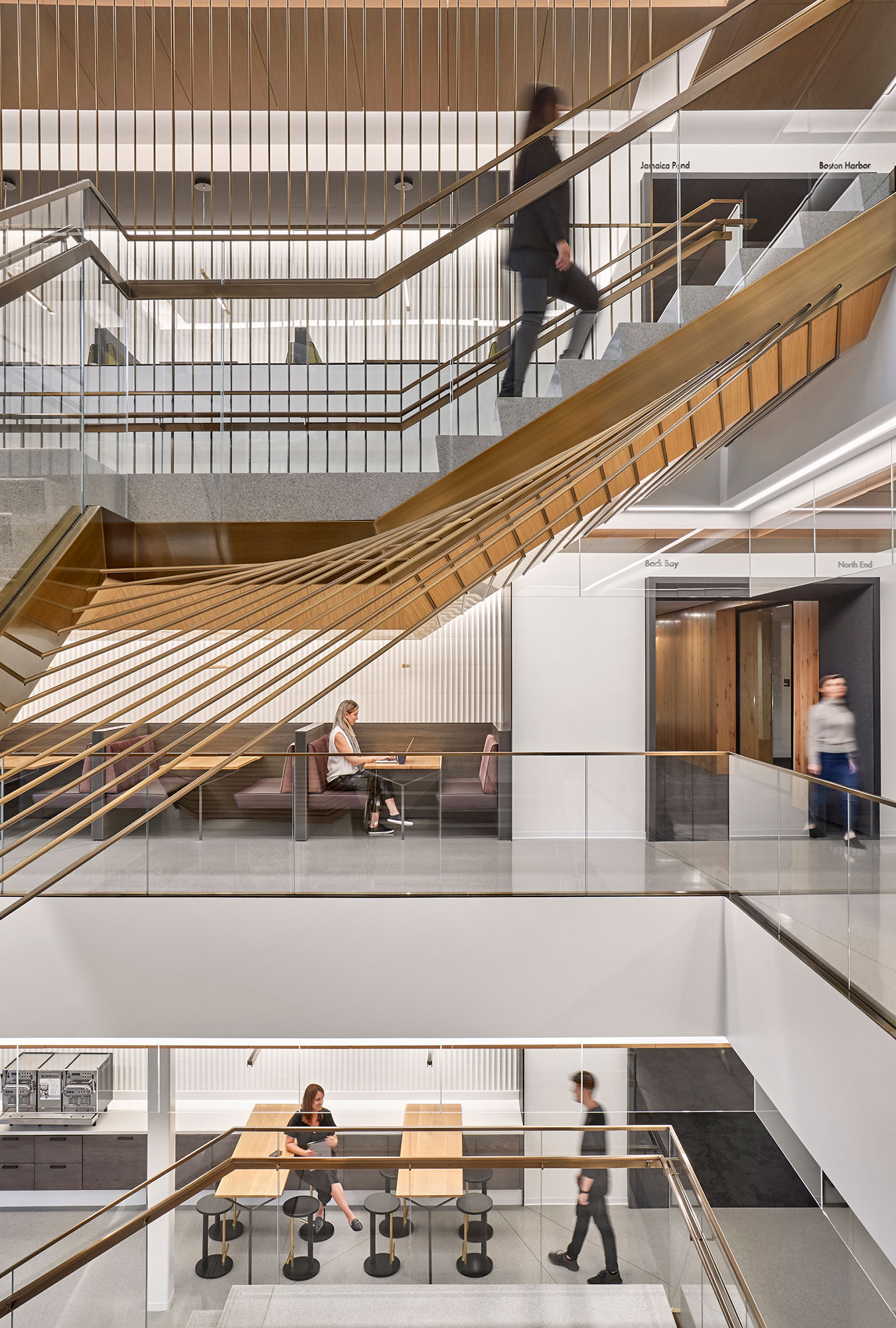 The renovated interiors for MathWorks campus show a connecting staircase and variety of workspaces.