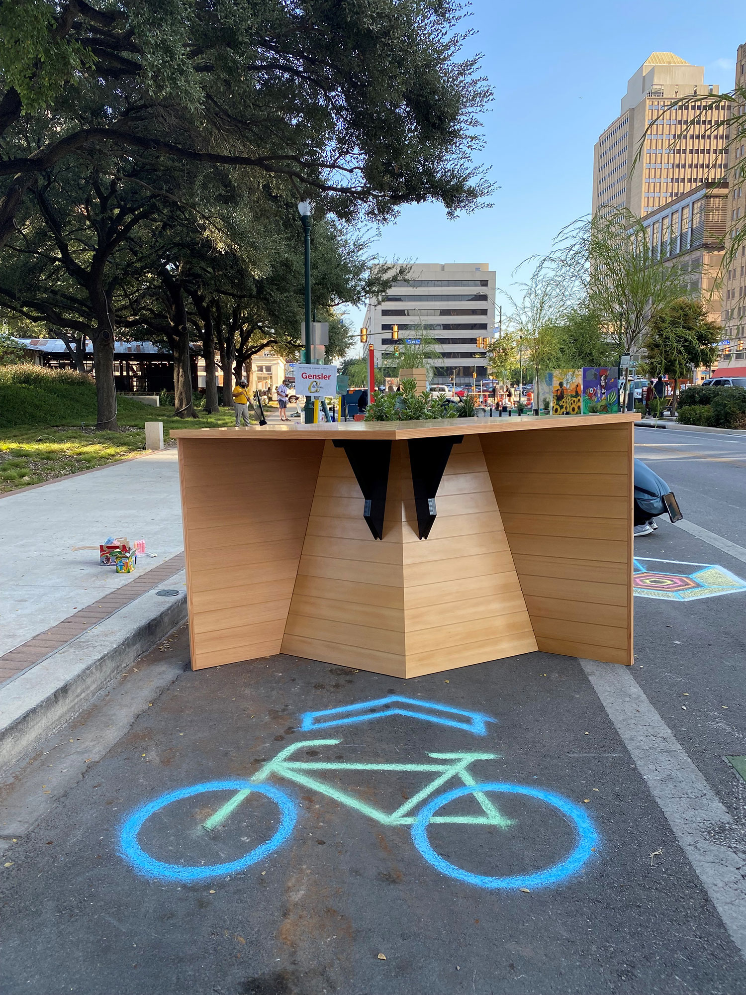 A parklet structure with bike parking and a high top bar