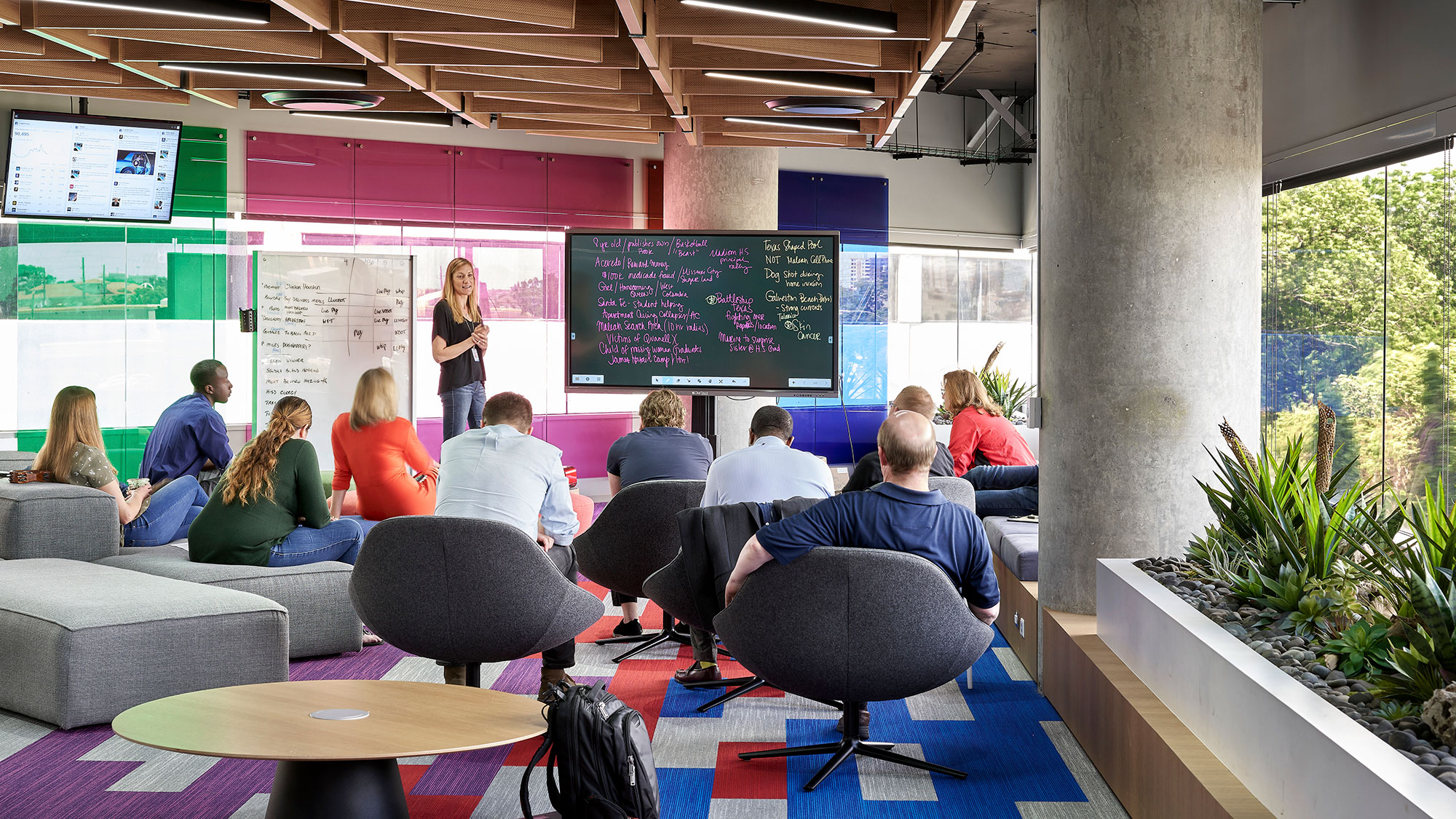 Workers gathering for a presentation inside a media workplace.