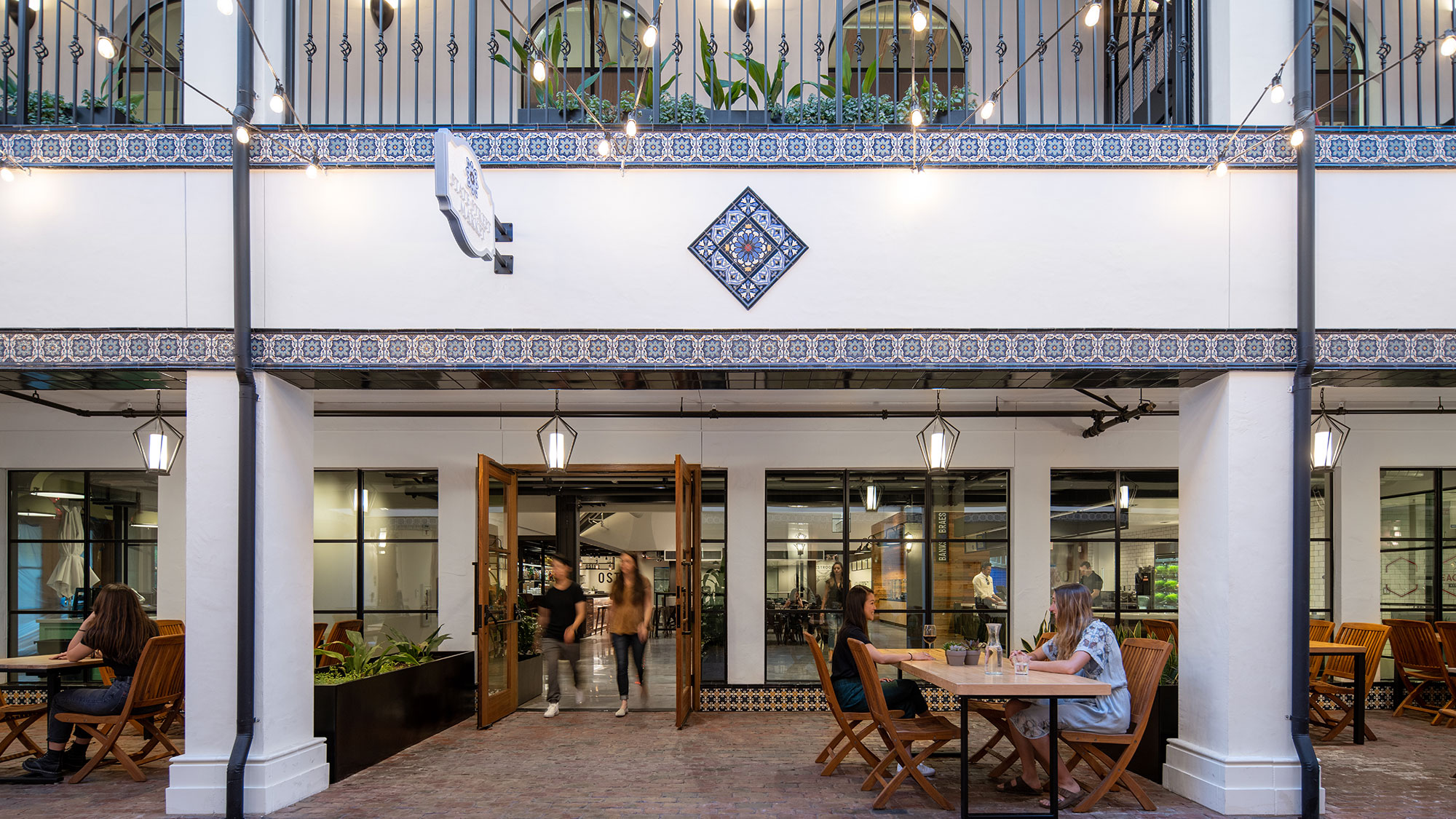 A building with a few people sitting at tables and chairs.