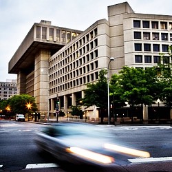 A street with a building in the background.