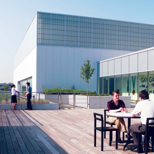 A group of people sitting at a table outside a building.