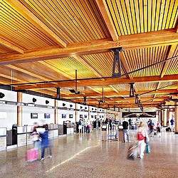 A group of people in a large room with a large ceiling.