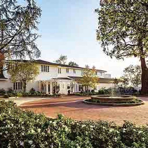 A large house with a fountain in the front.