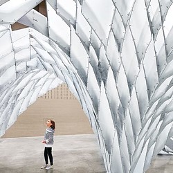 A person standing in front of a large white sculpture.