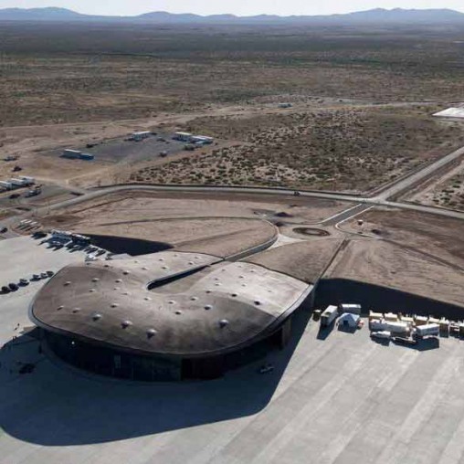 A large concrete structure with a road and cars in the background.