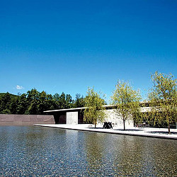 A body of water with trees and a building in the background.