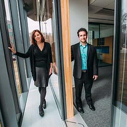 A man and a woman walking down a hallway.