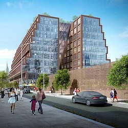 A group of people walking on a sidewalk next to a building.