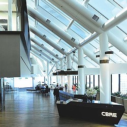 A large room with white pillars and a few people sitting at tables.