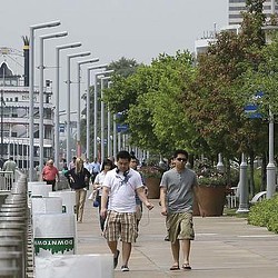 A group of people walking on a sidewalk.