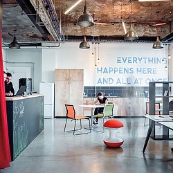 A couple of people sitting at a table in a room with a large ceiling and a couple of.