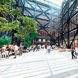 A group of people walking on a walkway between buildings.