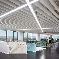 A group of people in a large room with windows and a large white ceiling.