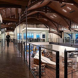 A large room with a few people and a large glass ceiling.