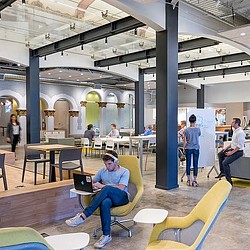 A person sitting in a chair with a laptop on the lap.