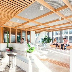 A group of people sitting on a couch in a room with a wood ceiling.