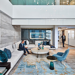 A person sitting in a chair in a room with a large glass wall.