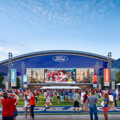 A group of people outside a stadium.