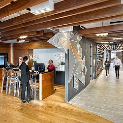 A man and woman looking at a large screen in a room with people.