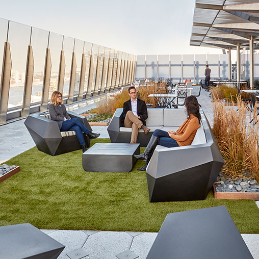 A group of people sitting on lounge chairs outside.