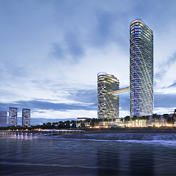 A couple of tall buildings by the water.