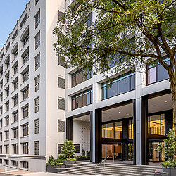 A building with a tree in front.