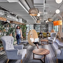 A person standing in a room with chairs and tables.