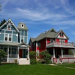 A couple of houses with a lawn in front of them.