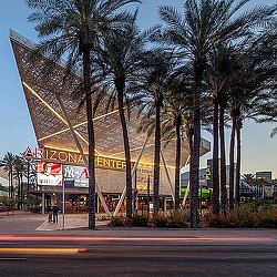 A building with palm trees in front of it.