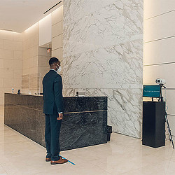 A man standing next to a large piece of art.