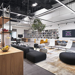 A room with a couch and chairs.