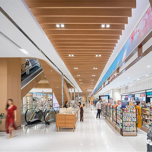 A long hallway with people and shopping carts.