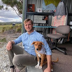 A person sitting on a chair with a dog.