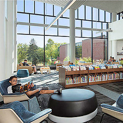 A person lying on a couch with a laptop.