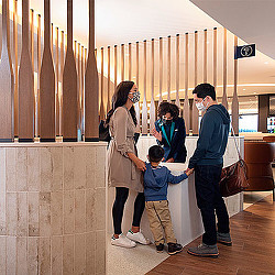A group of people standing in a room with a person and a child.