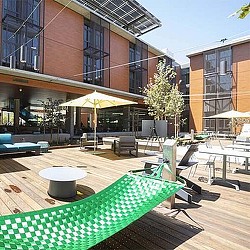 A patio with tables and chairs outside of a building.