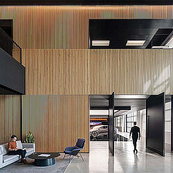 A man and a woman in a room with a car and a man sitting on a couch.