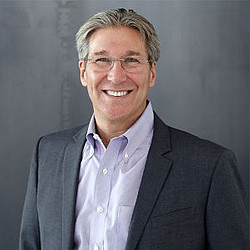 A man wearing a suit and glasses.