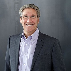 A man wearing a suit and glasses.