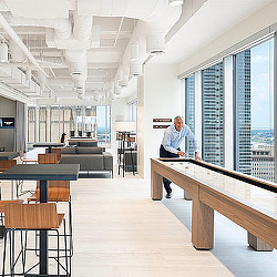 A person standing in a room with tables and chairs.