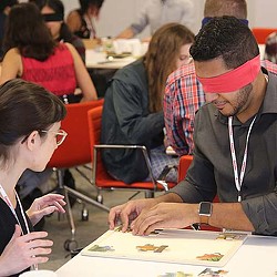A man and woman sitting at a table looking at a paper.