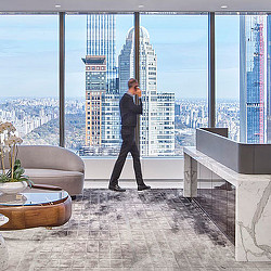 A person standing in front of a window overlooking a city.