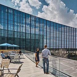 A man and woman standing in front of a glass building.