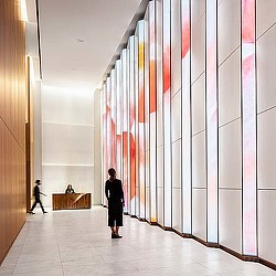 A person and a child walking in a hallway.