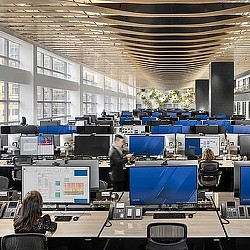A person standing in front of a group of people sitting at computers.