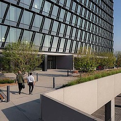 A couple of people walking outside of a building.